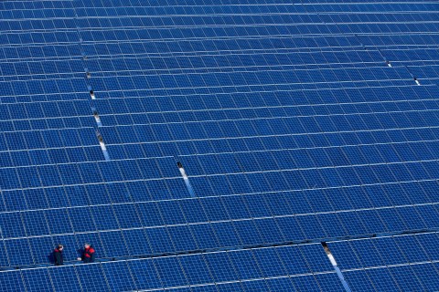 Two men stand in the new solar power plant of operating company Norddeutsche Energiegemeinschaft in Buetzow, Germany, March 15, 2013.
