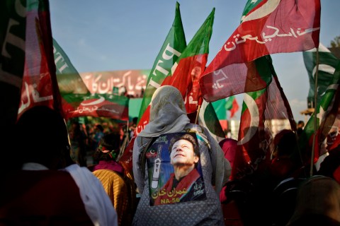 Pakistani supporters of former cricket star-turned-politician, and leader of Pakistan Tehreek-e-Insaf party, Imran Khan, wave his party's flag during a rally in Islamabad, May 9, 2013.