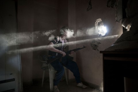 A rebel FSA fighter fires at enemy positions of Assad Forces as skirmishes break out on the front line in Bustan Al Qasr frontline in Aleppo, Syria, April 9, 2013.