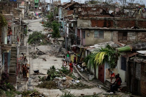 People walk on a street littered with debris after Hurricane Sandy hit Santiago de Cuba, Oct. 26, 2012.