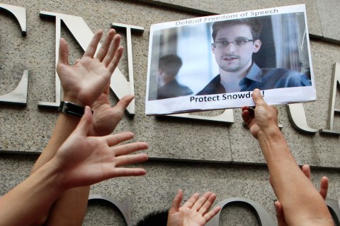 A supporter holds a picture of Edward Snowden, a former CIA employee who leaked top-secret information about U.S. surveillance programs, outside the U.S. Consulate General in Hong Kong Thursday, June 13, 2013. 