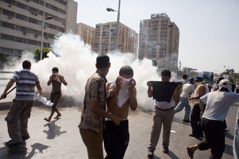 Egyptian protesters take cover from tear gas during clashes next the headquarters of the Republican Guard, in Cairo, Egypt, 05 July 2013. 