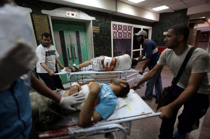Members of the Muslim Brotherhood carry an injured supporter of ousted Egyptian President Morsi during clashes with Republican guards forces in Cairo, on July 8, 2013.