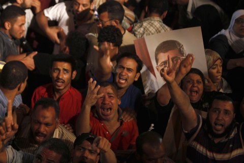 Supporters of Egypt's President Mohamed Mursi react after the Egyptian army's statement was read out on state TV, at the Raba El-Adwyia mosque square in Cairo