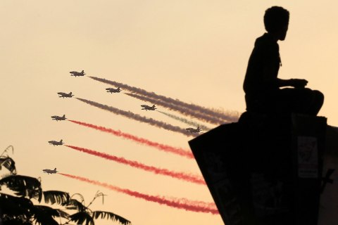 A man is silhouetted against the sunset as Egyptian military jets fly in formation over Tahrir square in Cairo July 4, 2013. 