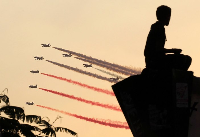 A man is silhouetted against the sunset as Egyptian military jets fly in formation over Tahrir square in Cairo July 4, 2013. 