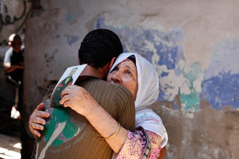 The mother of Palestinian Ateya Abu Moussa, who has been held prisoner by Israel for 20 years, reacts as she is hugged by her grandson after hearing news on the possible release of her son, in Khan Younis in the southern Gaza Strip July 28, 2013. 