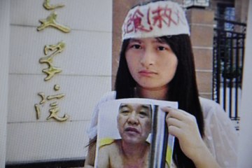 Zeng Shan, the daughter of Chinese businessman Zeng Chengjie, holds a picture of her father, in Changsha, China, on July 7, 2013.