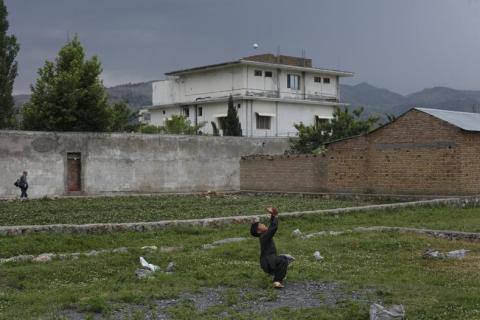 A young boy plays with a tennis ball in front of the compound where U.S. Navy SEAL commandos reportedly killed al Qaeda leader Osama bin Laden in Abbottabad, on May 5, 2011.