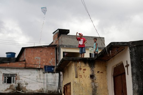 A boy flies a kite on the roof of the Chapel of Sao Sebastiao, where Pope Francis is expected to visit during his upcoming trip to Varginha slum in Manguinhos slums complex in Rio de Janeiro July 16, 2013