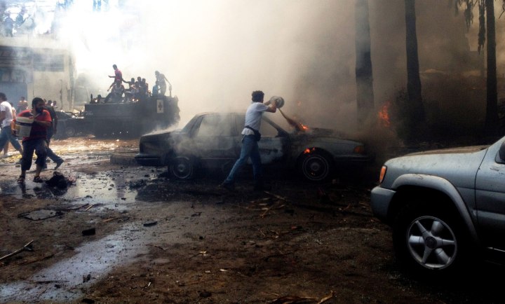Men try to extinguish fires at the site of an explosion in the northern city of Tripoli, Lebanon, on Aug. 23, 2013.