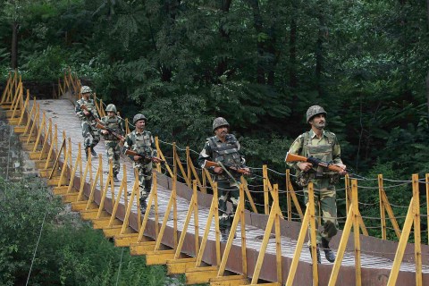 Indian BSF soldiers patrol over a footbridge built over a stream near LoC, a ceasefire line dividing Kashmir between India and Pakistan, at Sabjiyan sector of Poonch district