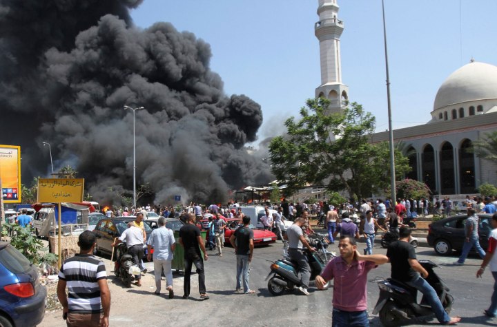 Smoke rises outside al-Taqwa mosque, one of two mosques hit by explosions, in Lebanon's northern city of Tripoli, on Aug. 23, 2013.