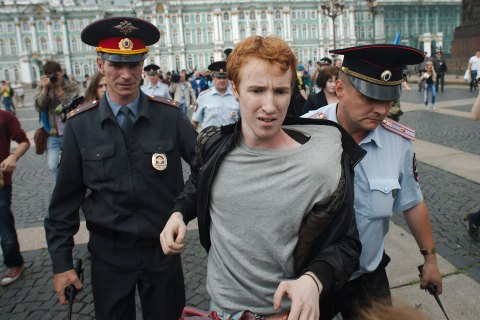 Kirill Kalugin, a participant of a picket against homophobia, was arrested by police officers after he was attacked by former paratroopers during Russian Paratrooper day in St. Petersburg, Aug. 2, 2013. 