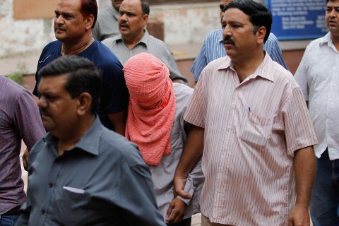 Delhi police officers escort  a juvenile accused of rape, outside the Juvenile justice board in New Delhi, Aug. 31, 2013. 