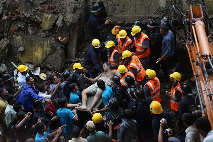 A survivor is rescued from the rubble after a four-story residential building collapsed in Mumbai, India, Sept. 27, 2013. 