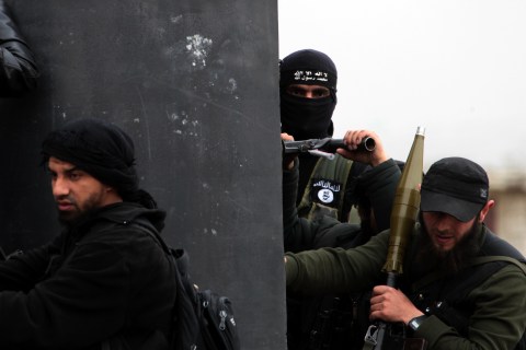 Center: A Turkish fighter of the jihadist group Al-Nusra Front, bearing the flag of Al-Qaeda on his jacket, holds position with fellow comrades on April 4, 2013 in the Syrian village of Aziza, on the southern outskirts of Aleppo.