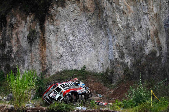 A view shows an autobus at its crash site after going off a cliff in San Martin Jilotepeque