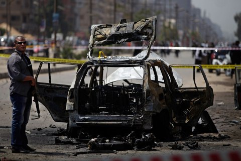 Egyptian security personnel gather at the scene of a bomb attack targeting the convoy of Egypt's Interior Minister Mohammed Ibrahim, in Nasr City, Cairo, Sept. 5, 2013.