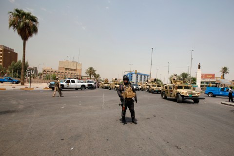 Iraqi security forces stand guard at a street amid tight security measures by Iraqi security forces that sealed off the roads around a protest site in Baghdad