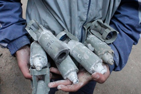 A boy holds unexploded cluster bombs after jet shelling by forces loyal to Syria's President Bashar al-Assad in the al-Meyasar district of Aleppo, Syria Feb. 21, 2013.   
