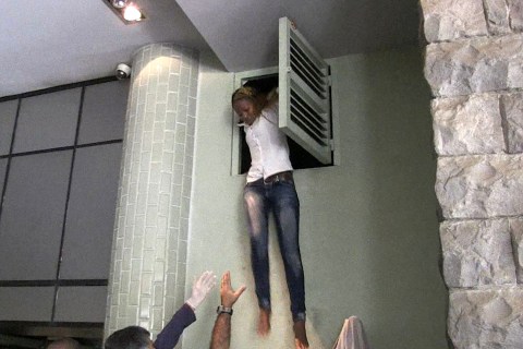 A Kenyan woman comes out of an air vent where she was hiding during an attack by masked gunmen at a shopping mall in Nairobi on Sept. 21, 2013. 