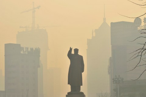 A statue of China's late Chairman Mao is seen in front of buildings during a hazy day in Shenyang, Liaoning province