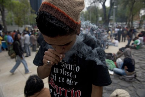 A man smokes marijuana during the "Marijuana Festival" for its legalization at Luis Pasteur square, in front of building of the Mexican Senate in Mexico City, on Jan. 20, 2013.