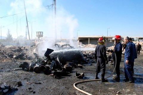 SANA handout shows firefighters extinguishing a vehicle on fire after a suicide bomber in a truck carried out an attack at the eastern entrance of Hama city