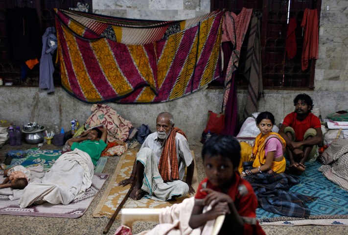 People take shelter at a wedding hall in the eastern Indian state of Odisha, October 12, 2013.