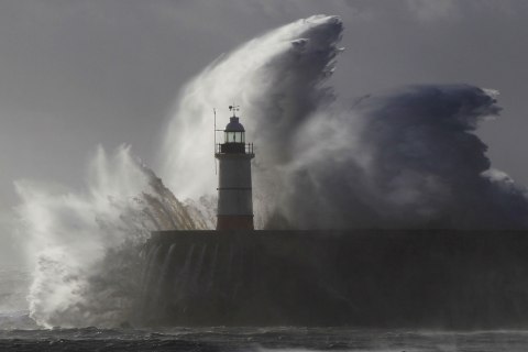 Waves crash against a lighthouse during storms that battered Britain and where a 14-year-old boy was swept away to sea at Newhaven in South East England