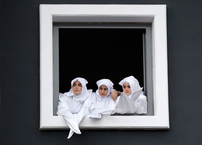Turkish Shi'ite girls watch a re-enactment of the battle of Kerbala on a huge screen during an Ashura procession in Istanbul