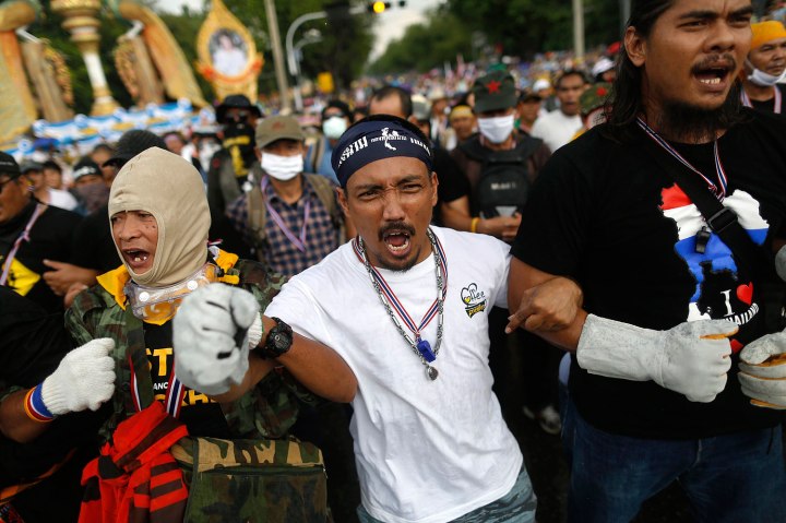 Anti-government protesters shout as they get ready to attack a police barricade near the Government house in Bangkok