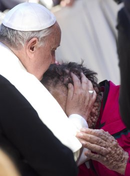 Pope Francis caresses a sick person in Saint Peter's Square at the end of his General Audience in Vatican City, November 6, 2013.