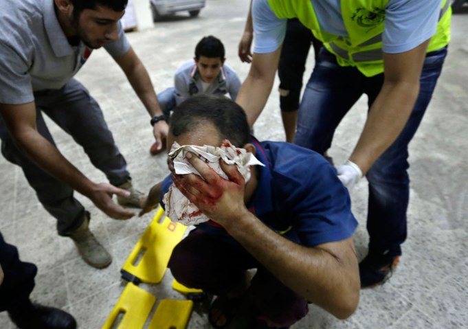 Hezbollah civil defense workers, help an injured man at the scene where two explosions have struck near the Iranian Embassy, in Beirut, on Nov. 19, 2013.