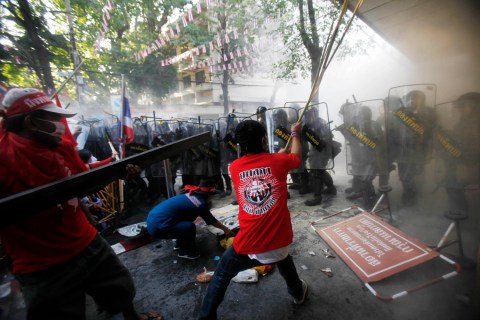 Anti-government "red shirt" protesters scuffle with Thai security forces as they advance through their camp during clashes in central Bangkok