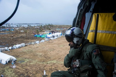 A U.S. Navy MH-60S helicopter drops supplies at Tacloban Air Base in Philippines