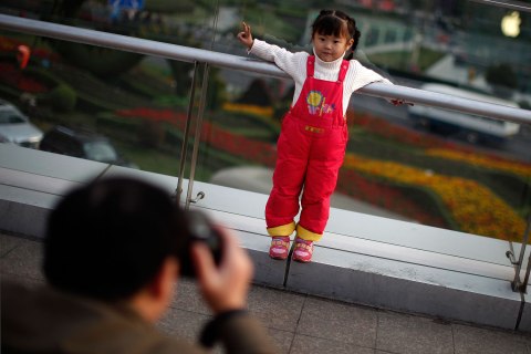A girl poses for a photograph at a commercial area of downtown Shanghai