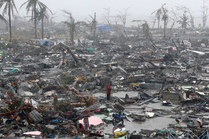 Survivors stand among debris and ruins of houses destroyed after Super Typhoon Haiyan battered Tacloban city in central Philippines
