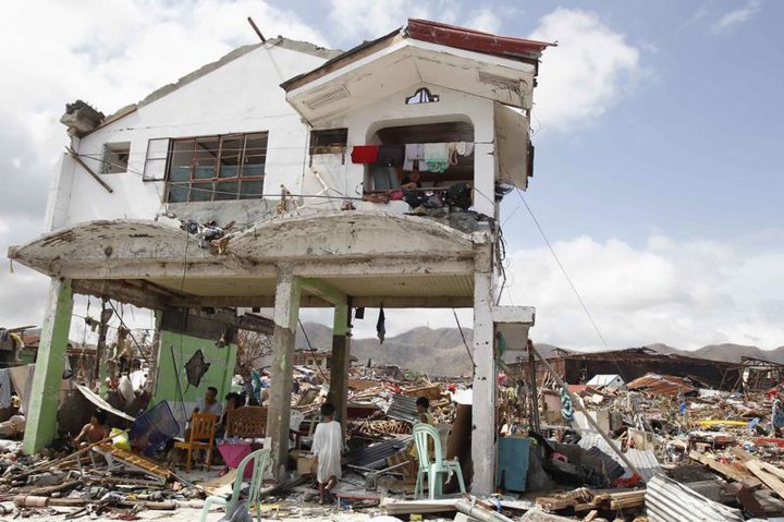 Survivors stay in their damaged house after super Typhoon Haiyan battered Tacloban city