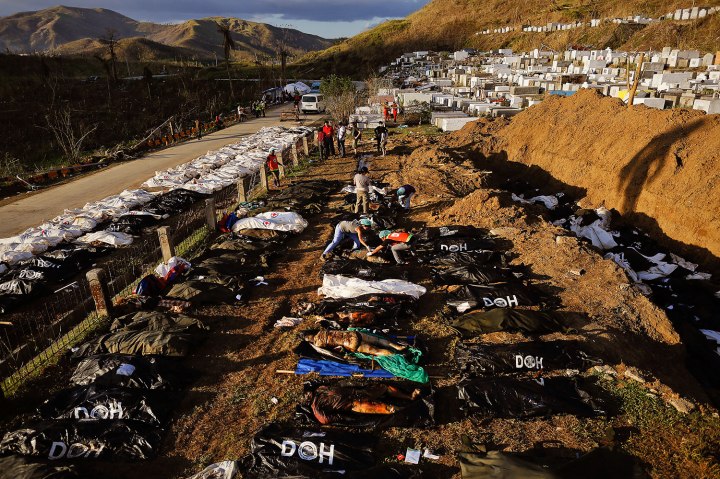 Forensic experts work on a mass grave with bodies of victims of Typhoon Haiyan just outside Tacloban