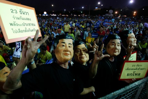 Supporters of People Power Party wear masks of former Thai PM Shinawatra during an election campaign rally in Bangkok