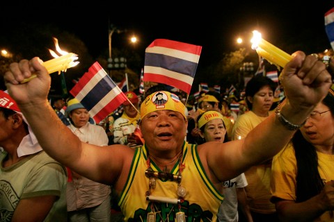 Thai demonstrators hold candles during rally against Thai PM Thaksin outside Government House in Bangkok