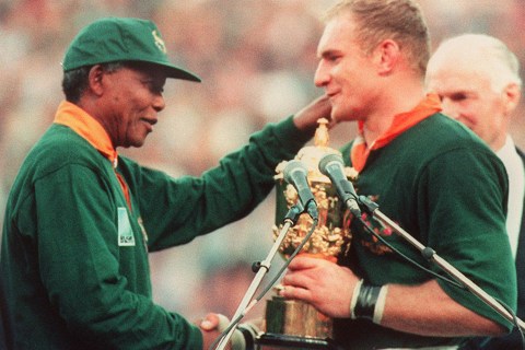 South Africa's president Nelson Mandela congratulates South Africa's rugby team captain François Pienaar before handing him the William Webb trophy after his team's victory over New Zealand in the final of the Rugby World Cup at Ellis Park in Johannesburg, June 24, 1995.