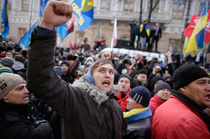 Protestors wave flags and shout slogans outside parliament in Kiev