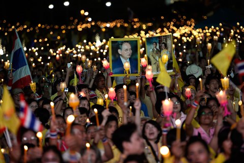 Anti-government protesters hold candles as they take part in birthday celebrations for Thailand's revered King Bhumibol Adulyadej, at the occupied Government buildings in Bangkok