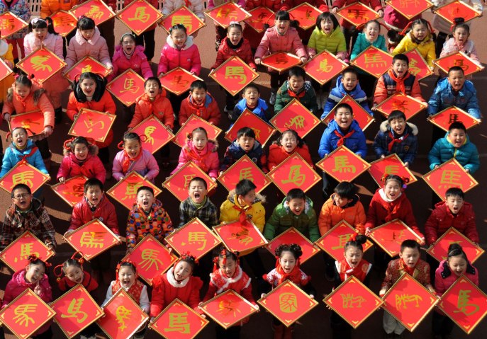 Young Chinese students show  paper-cuts with the Chinese character, Ma, meaning Horse, to celebrate the upcoming Year of Horse in China's lunar calendar at Jiujiang Primary School in Jiujiang city, east Chinas Jiangxi province, on Dec. 31, 2013.
