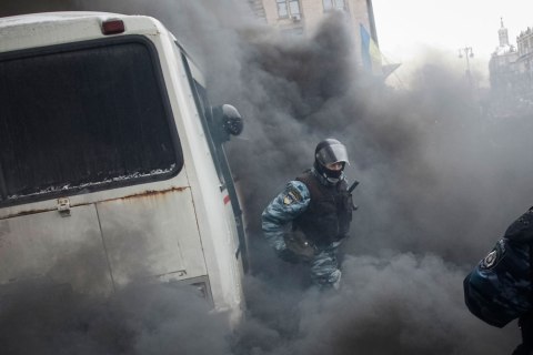 A Ukrainian riot police leaves a bus after protesters threw a smoke grenade, outside City Hall in Kiev