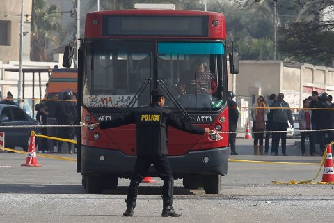 A policeman stands guard at the scene of a bomb blast that damaged a bus near the Al-Azhar University campus in Cairo's Nasr City district
