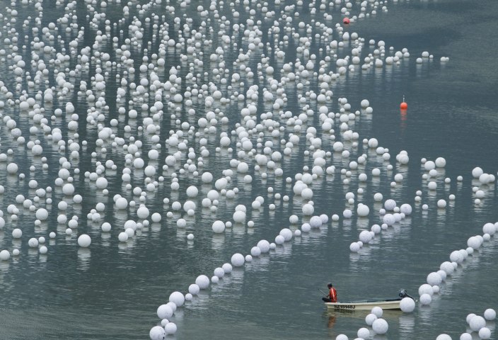 A worker takes a break while arranging "wishing spheres" along Marina Bay in Singapore, on Dec. 30, 2013.